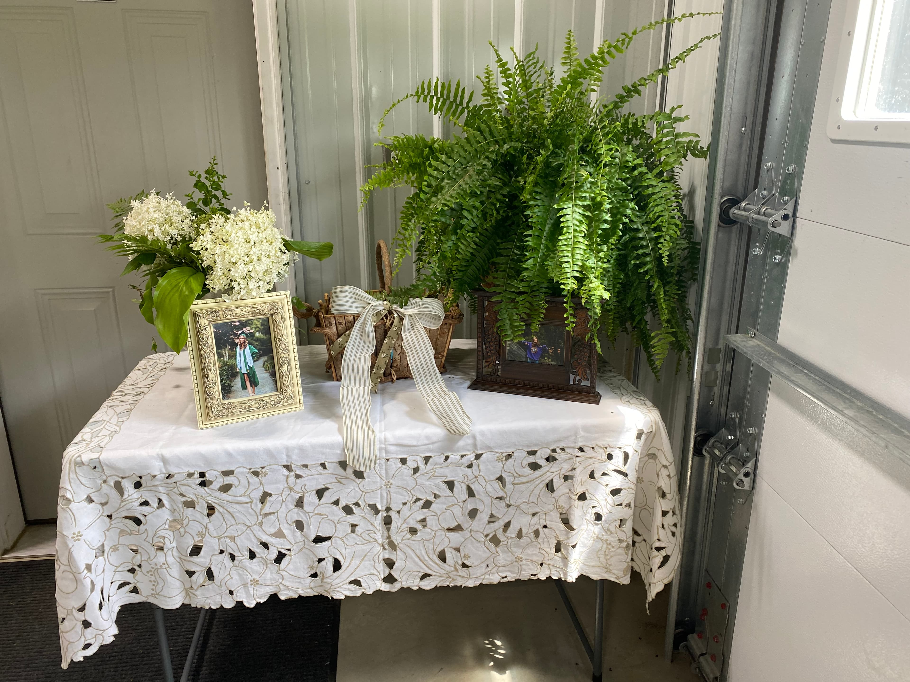 Elegant table display with ferns and photo frames by EC Collective