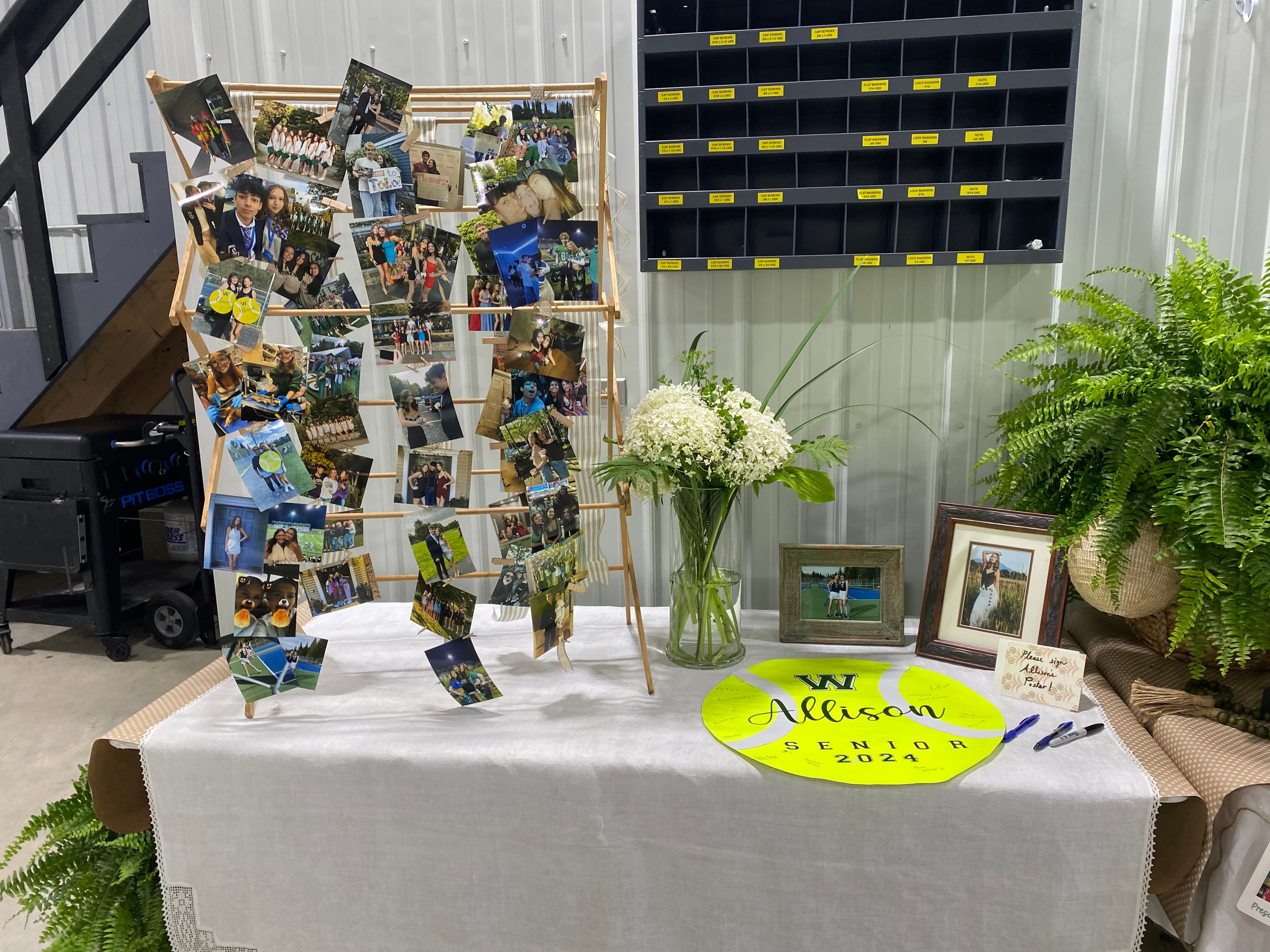 Graduation photo display table with ferns styled by EC Collective
